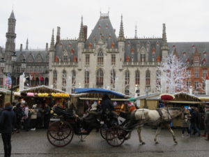A horse and buggy deliver tourists to the Christmas market in Bruges, Belgium